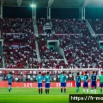 Home 21 몰타 출신 축구선수 - **Vibrant Maltese Football Match Day:** A wide shot capturing the energetic atmosphere inside a mode...